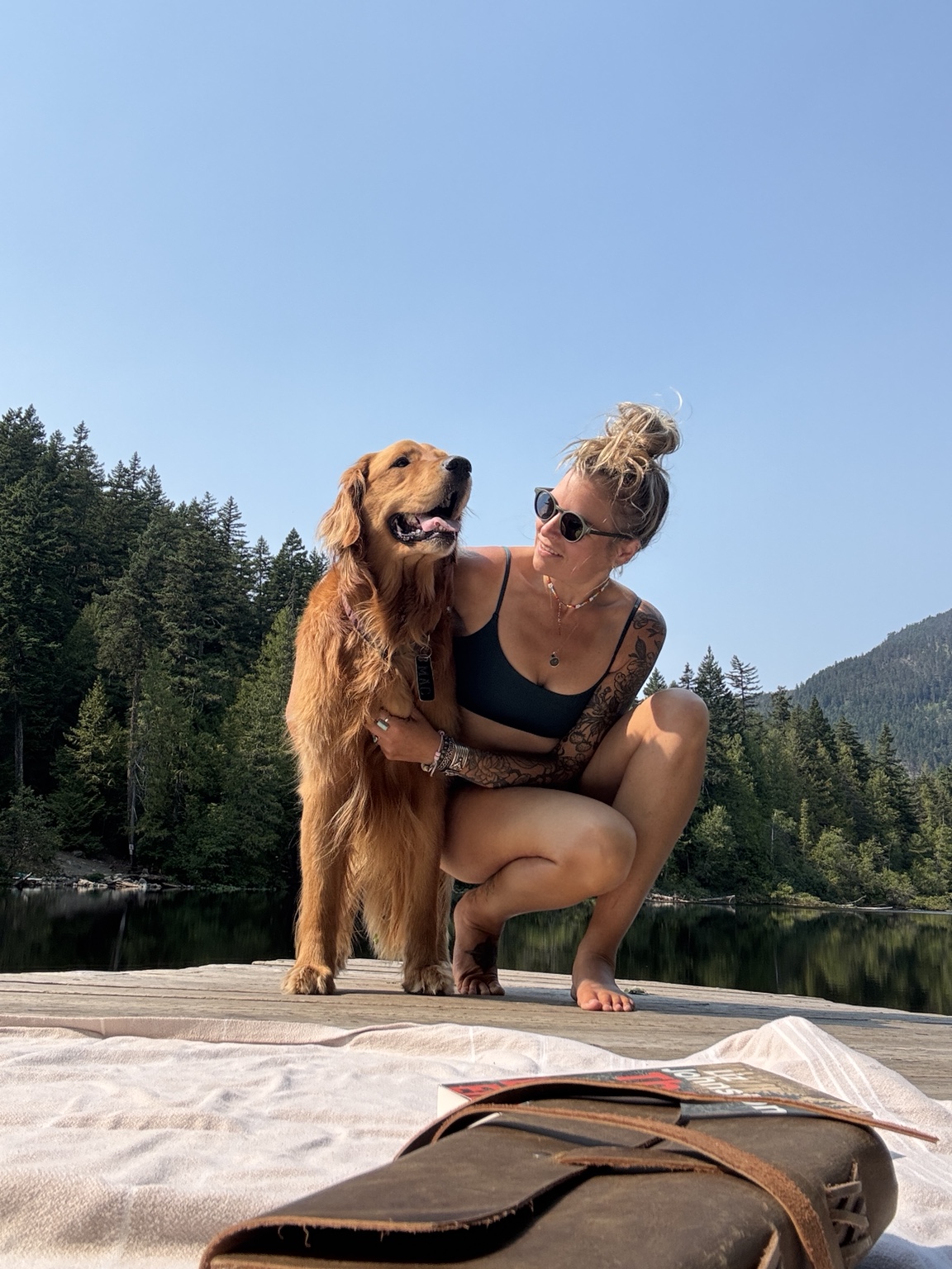 Hannah with her golden retriever Mac beside a mountain lake